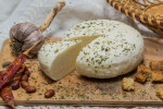 Traditional Russian Adygei cheese with croutons, red peppers and garlic served on wooden cutting board